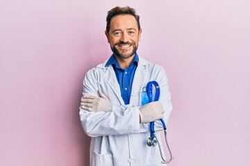 Middle age man wearing doctor uniform smiling with a happy and cool smile on face. showing teeth.