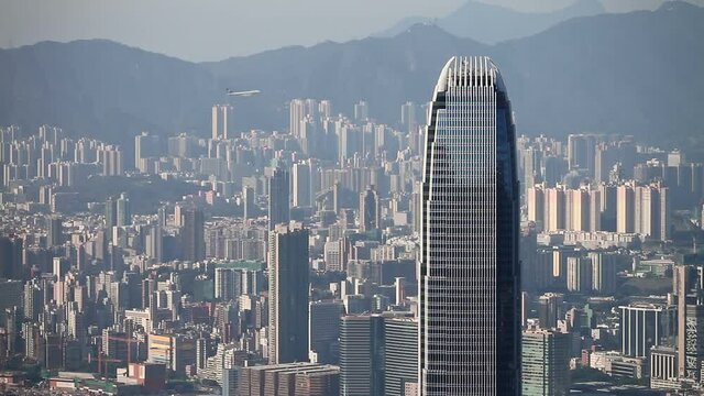Skyscrapers of the financial and business district and airplane crossing the sky. Hong Kong, Kowloon Peninsula, ICC, Sky100