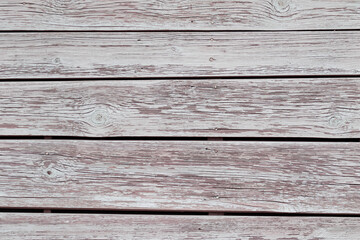 The background is the texture of a wall of large planks painted with white paint which peeled from...