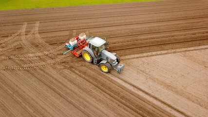 Traktor mit Sämaschine bei der Aussaat von Mais auf einem Acker, Landwirtschaft, Ernährung, Pflanzenanbau © keBu.Medien