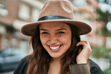 Young hispanic tourist woman smiling happy standing at the city.