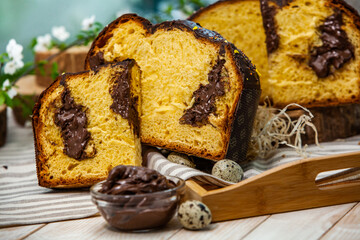 Home Made Panettone. Traditional Italian sweet bread. Panettone with a slice served on a wooden table.
