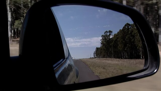 Side Mirror of Car (or Wing mirror) on Road. Travel Concept, Suggests Moving On from the Past. Close Up.  