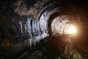 Dark underground tunnel. Light at the end of tunnel