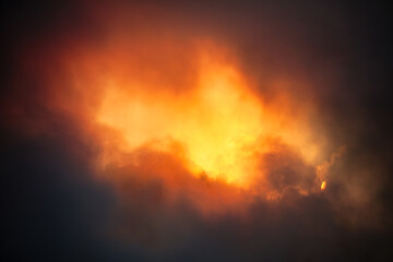 Fototapeta na wymiar Fiery burst of sunlight break in the dark clouds - beautiful spectacular sunset