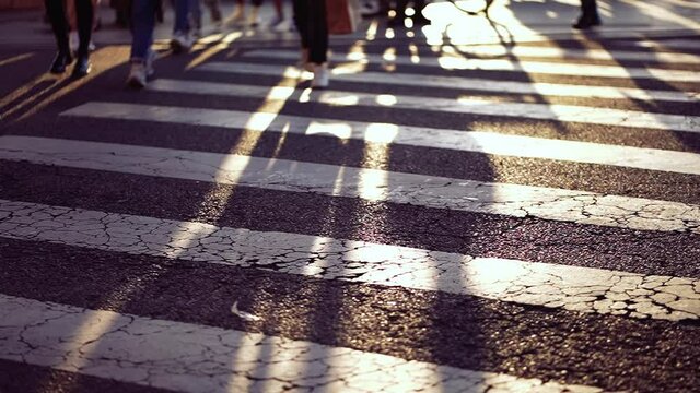 Pedestrians feet walking on zebra lines in city crossing street