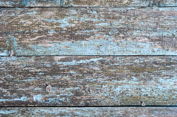 Photo of the texture of old boards with peeling paint. Remnants of blue paint.