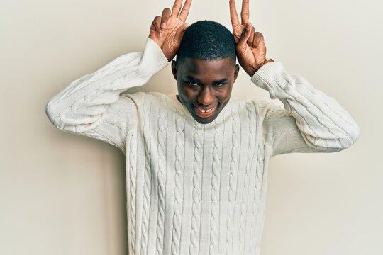 Young african american man wearing casual clothes posing funny and crazy with fingers on head as bunny ears, smiling cheerful