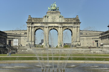 Obraz premium La pièce d'eau circulaire et sa fontaine devant les arcades majestueuses du Cinquantenaire à Bruxelles 