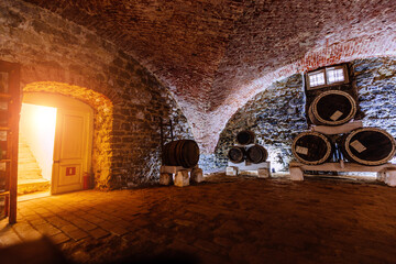 Old red brick vaulted wine cellar with barrels