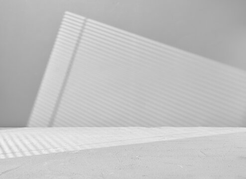 Gray background for product presentation with window light through blinds