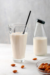 Almond milk gluten-free in glass containers on a light background. Organic natural vegetarian drink. Health concept. Vertical position