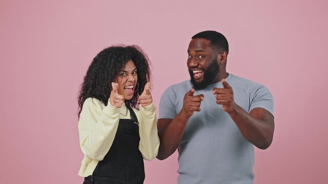 We choose you. Happy african american man and woman pointing fingers to camera, smiling and showing thumbs up
