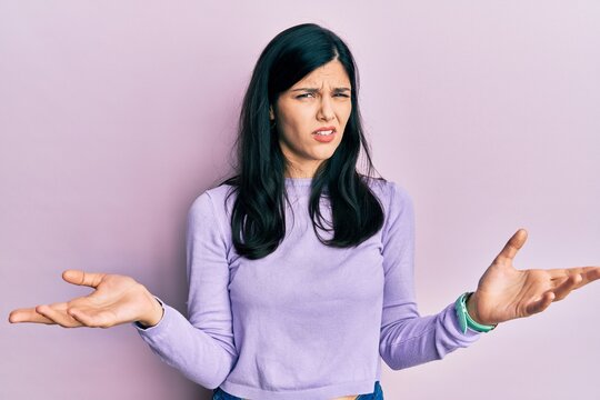 Young hispanic woman wearing casual clothes clueless and confused with open arms, no idea concept.