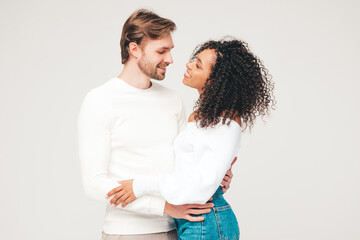 Smiling beautiful woman and her handsome boyfriend. Happy cheerful multiracial family having tender moments on grey background  in studio. Multiethnic models hugging. Embracing each other.Love concept