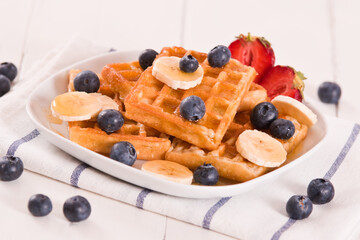 Waffles with blueberries, bananas and honey.