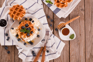 Waffles with blueberries and whipped cream.