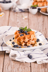 Waffles with blueberries and whipped cream.