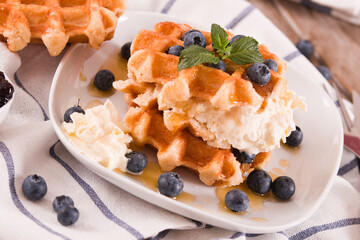 Waffles with blueberries and whipped cream.