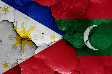 flags of Philippines and Maldives painted on cracked wall