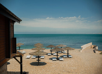 Wooden beach umbrellas by the sea in clear weather