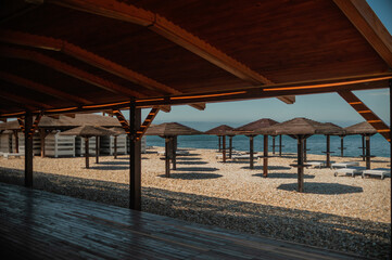 Wooden beach umbrellas by the sea in clear weather