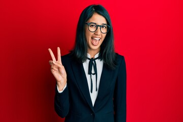Beautiful asian young woman wearing business suit smiling with happy face winking at the camera...