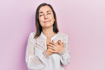 Middle age hispanic woman wearing casual clothes smiling with hands on chest with closed eyes and grateful gesture on face. health concept.