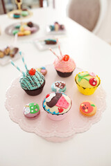 Close up image of assorted colorful cupcakes and macaroons