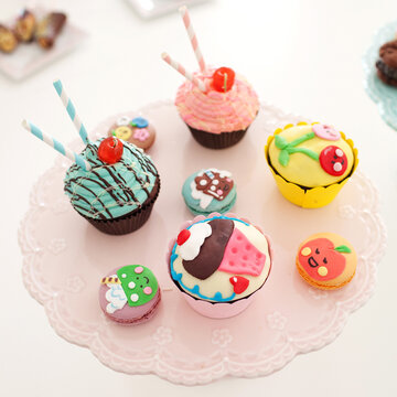 Close up image of assorted colorful cupcakes and macaroons