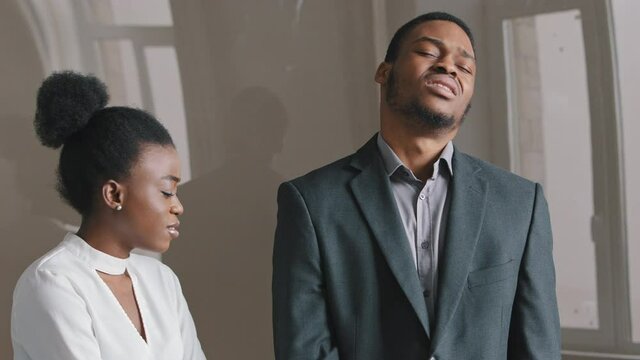 Concentrated 25's African American young man holding paper document feeling unhappy with negative news. Disappointed employee receives notice of dismissal from boss. Sad desperate woman losing job