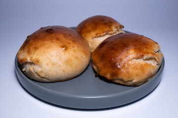 Homemade burger bread. Organic hamburger bread. Close-up home bread on the gray plate. Three organic bread rolls.