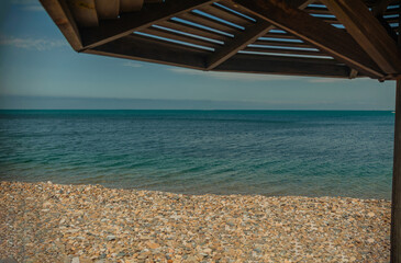 Wooden beach umbrellas close up by the sea in clear weather