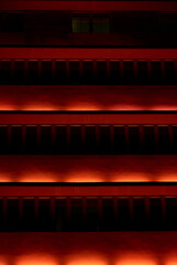 Red illuminated modern building facade at night