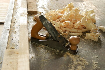 plane and fresh shavings on the workbench in the carpenter's shop