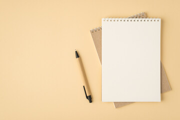 Top view photo of two organizers and pen on isolated beige background with copyspace