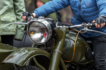 Fototapeta na wymiar Dnepr MT-11 motorcycle / motorcyclist / headlight / green bike / biker in blue jacket