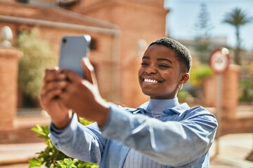 Young african american woman smiling happy making selfie by the smartphone at the city