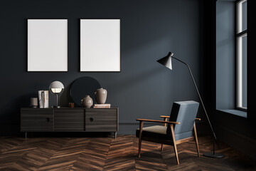 Dark blue living room interior with armchair and lamp near window, two posters