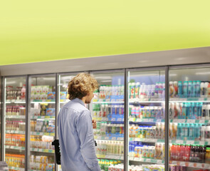 Man choosing frozen food from a supermarket freezer.