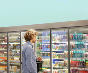 Man choosing frozen food from a supermarket freezer.