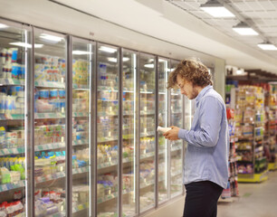 Man choosing frozen food from a supermarket freezer.