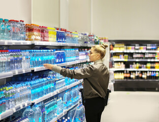 Woman  Buying a bottle of water in a supermarket