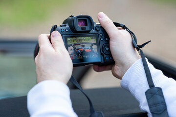 Person taking a car picture by a digital camera