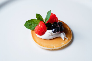 Pancake with whipped and cream, raspberries and blueberries. Breakfast for a healthy diet.
