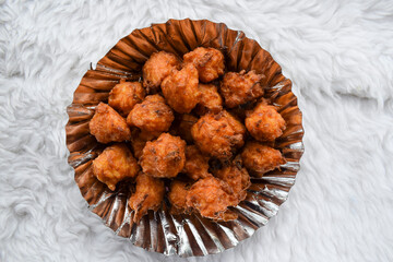 Tasty rice bhajiya or Pakoda also known as rice ball fritters is made out of Leftover rice, gram flour served in plate with hot cup of Indian masala tea or chai - obrazy, fototapety, plakaty