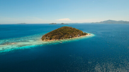 Aerial view of tropical beach on the island Banana, Philippines. Beautiful tropical island with sand beach, palm trees. Tropical landscape: beach with palm trees. Seascape: Ocean, sky, sea. Travel