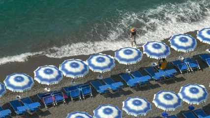 Photo sur Plexiglas Plage de Positano, côte amalfitaine, Italie high angle shot of a woman standing next to beach umbrellas on positano beach