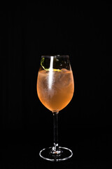 refreshing alcoholic drink with berries, ice vodka and gin, lemon peel served in glass cup on the counter on blurred background
