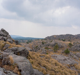 A Hispanic hiker on top of mount Tlaloc under a cloudy sky in Mexico